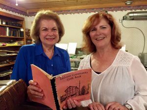 Program committee chairwoman Linda (Cinson) Faa is pictured here (left) looking over a vintage Malvern cookbook brought in by society follower Lorraine (Galay) Baldwin.